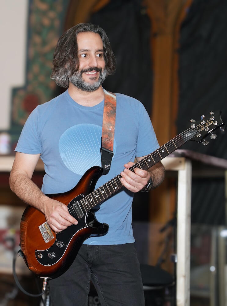 Joe DePasquale with Guitar A high-contrast photograph of Joe DePasquale performing on electric guitar during a Baltimore Rock Opera Society production.